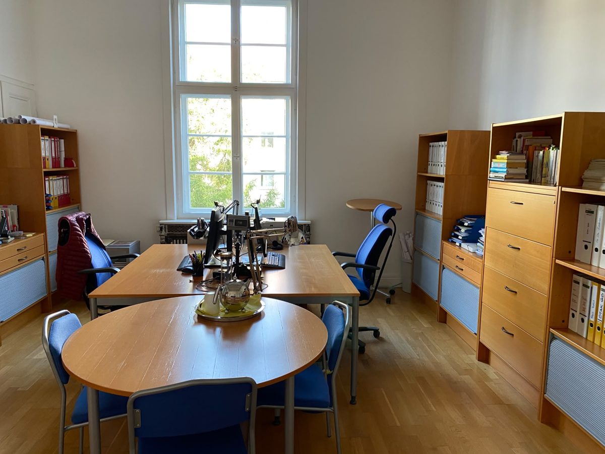 Großraumbüro mit Arbeitsplätzen und Regalen